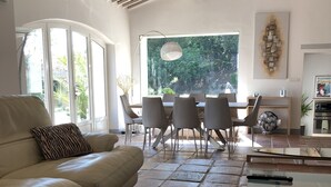 A modern living room with a sofa, a glass coffee table, a dining area with chairs, and a large window with a view of greenery. - EXCEPTIONAL AND RARE, 15 km from MARSEILLE, BE 3 km FROM AUBAGNE, MAS DE STANDING (Roquevaire)