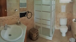 Une salle de bain comprenant un lavabo, des toilettes et un espace douche.