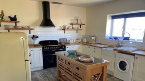 A kitchen with a stove, oven, sink, and washing machine. - Country Retreat Sleeps 2 Near Cymyran Beach (Holyhead)