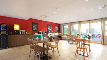 Ein modernes Restaurant mit Holztischen und -stühlen, einer roten Ziegelfassade und großen Fenstern.