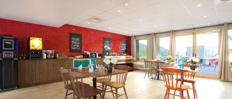 Ein modernes Restaurant mit Holztischen und -stühlen, einer roten Ziegelfassade und großen Fenstern.