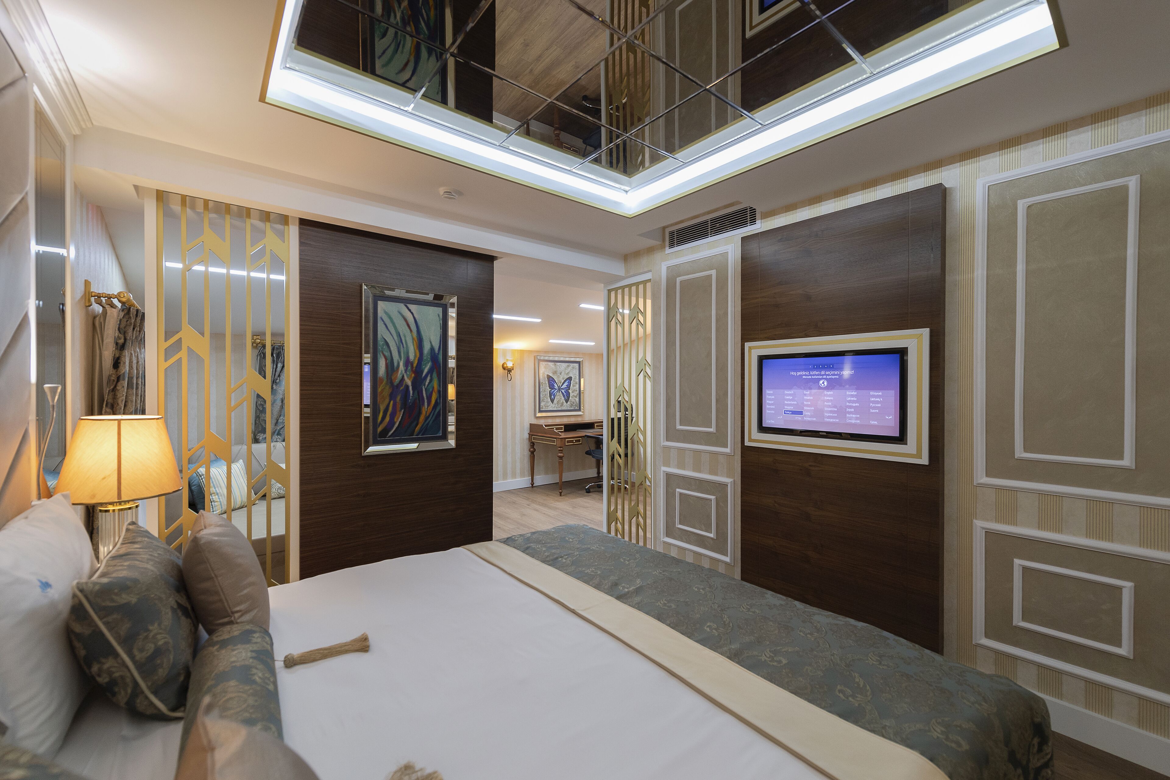 Ein Hotelzimmer mit einem großen Bett, einem Schreibtisch, einem Fernseher und einer Decke mit einem Oberlicht.