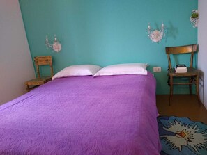 A room with a bed, two chairs, and a wall-mounted shelf with books. - Very Large Apartment with Exclusive Outdoor Pool (Sleeps 6), Olive Grove, Ocean View (Diano Castello)