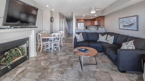 A living room with a TV, fireplace, dining table, and sofa.