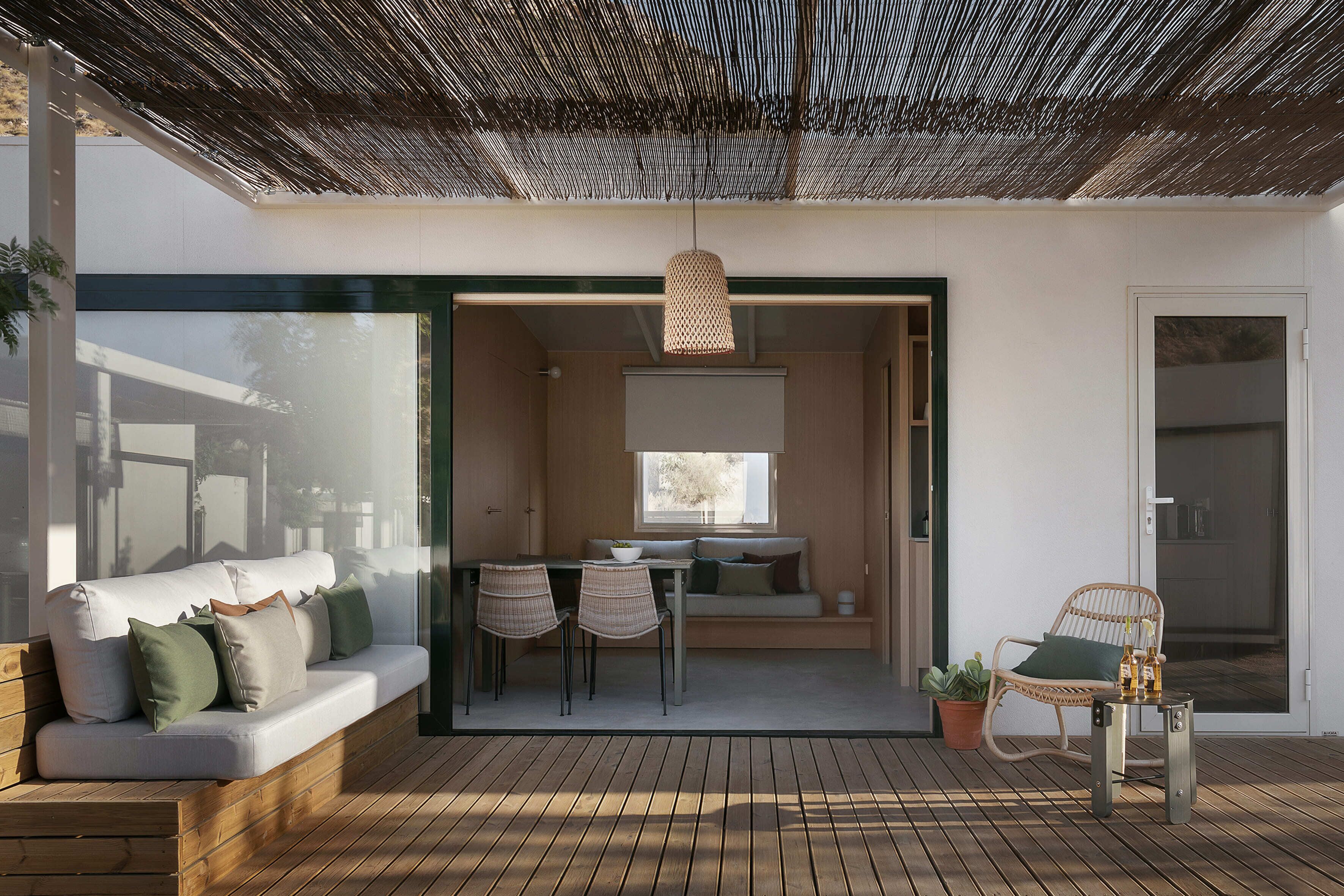 Un área de estar exterior moderna con un sofá, sillas y una mesa.