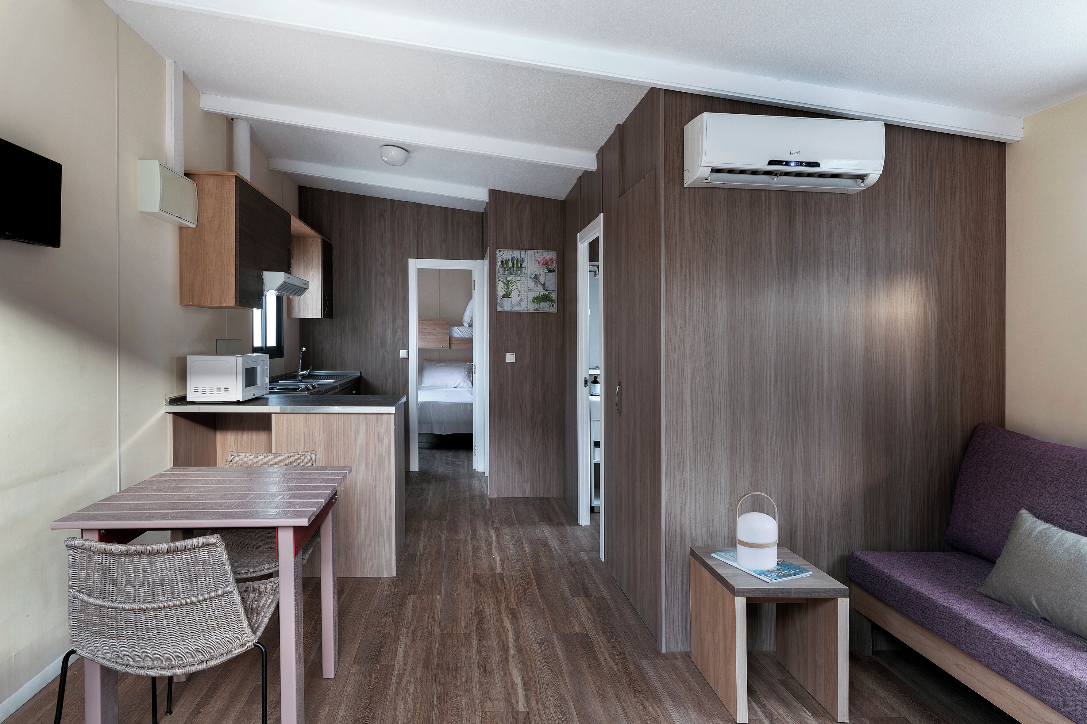 Een compacte hotelkamer met een kitchenette, een eethoek en een zithoek.