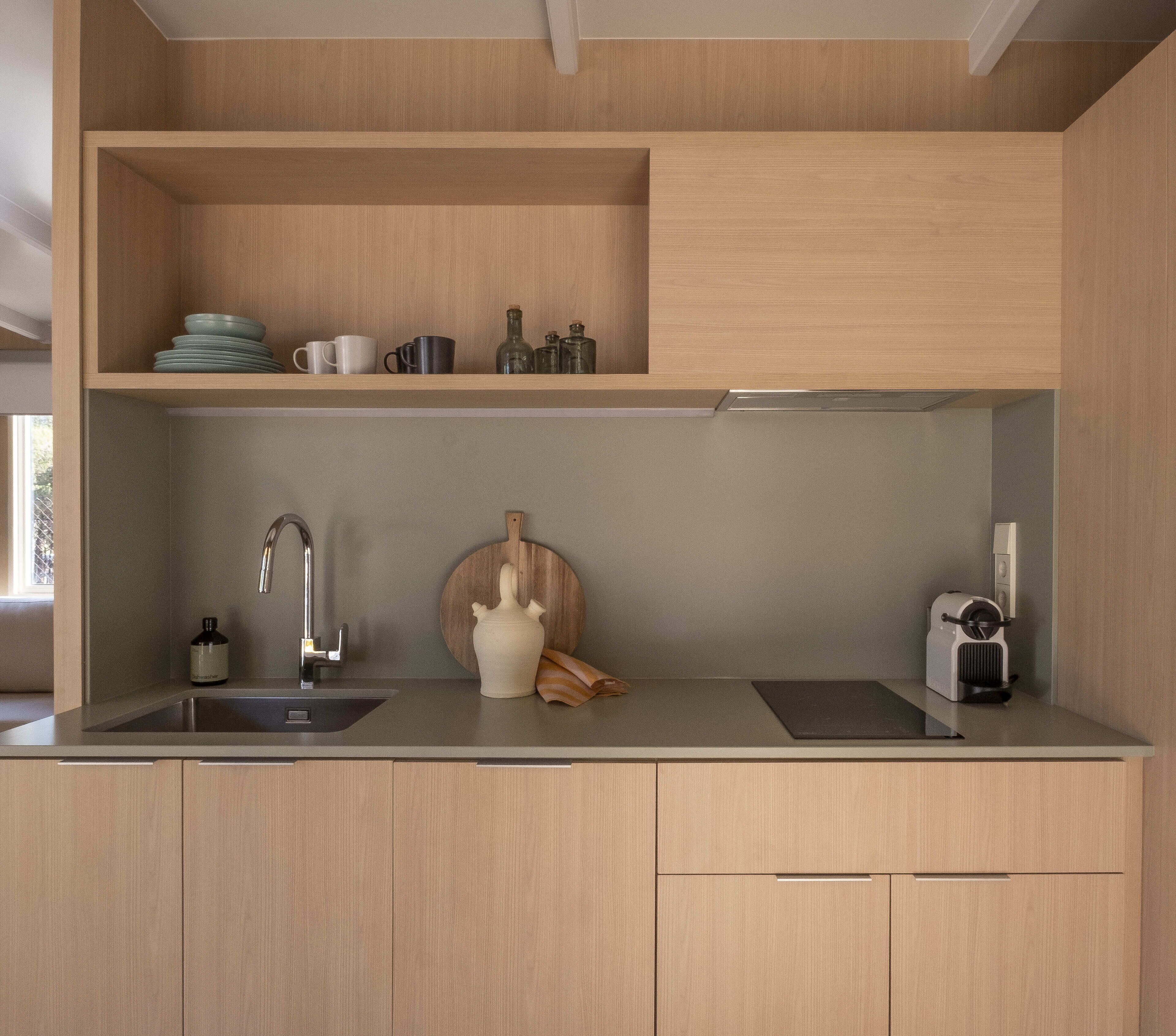Une cuisine moderne avec des meubles en bois, un évier en acier inoxydable et un four encastré.