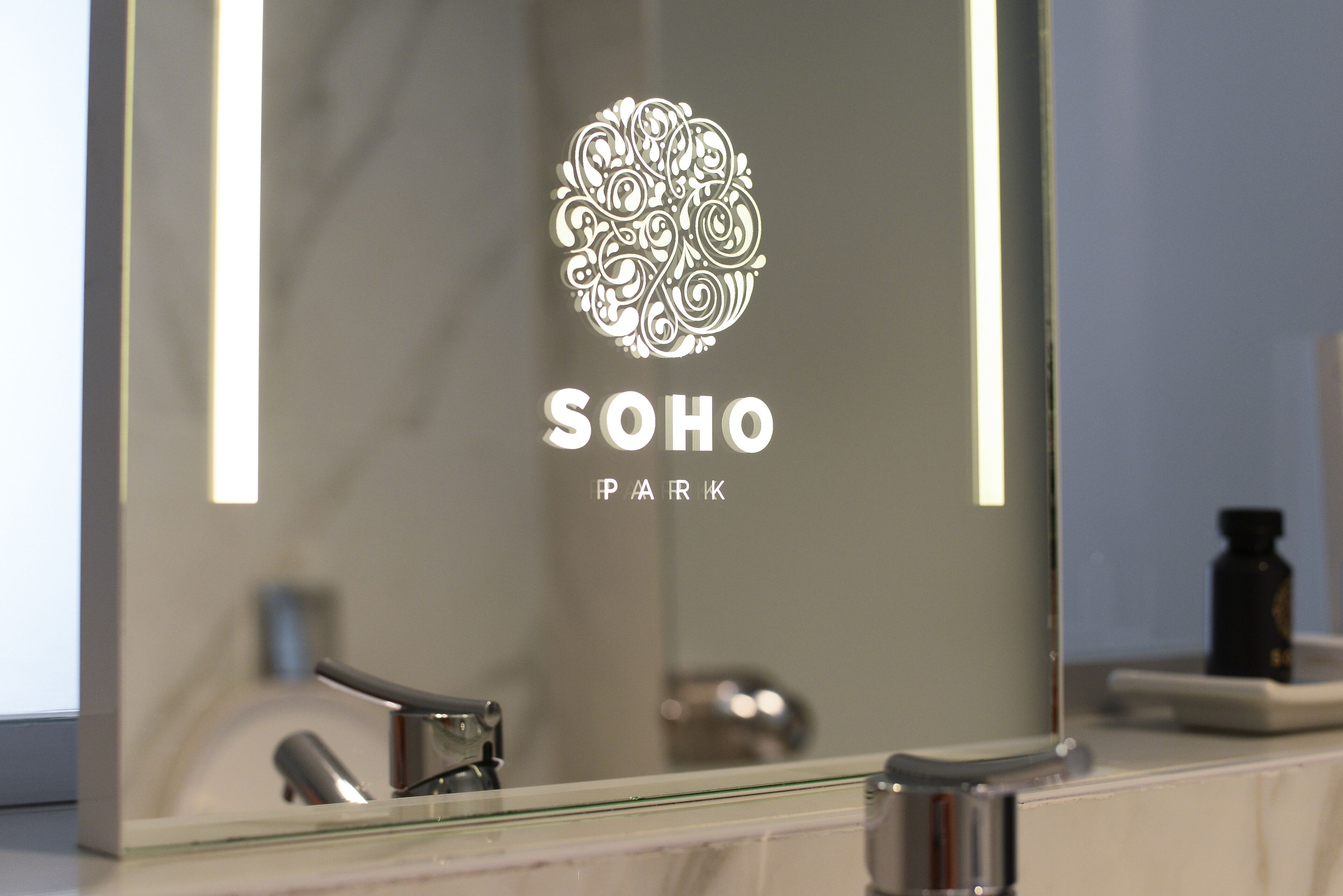 A bathroom mirror with a logo and name "SOHO PARK".
