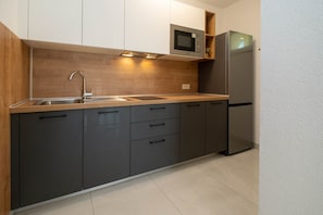 Køleskab, mikrobølgeovn, kogeplade, køkkentøj/tallerkener/redskaber