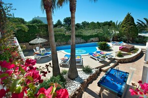 A poolside area with lounge chairs, a pool, and a table tennis table. - Villa Hortet with 4 bedrooms, central location near the marina (Cala Dor)