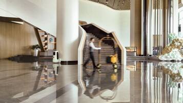 Experience the sleek lobby with a curved staircase, comfortable seating area, and modern design.