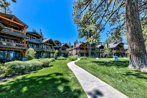 A resort with multiple buildings, a paved walkway, and surrounding greenery.