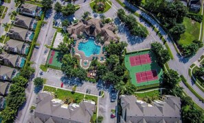 Residents can enjoy a serene atmosphere surrounded by lush greenery and a central swimming pool with a small waterfall.