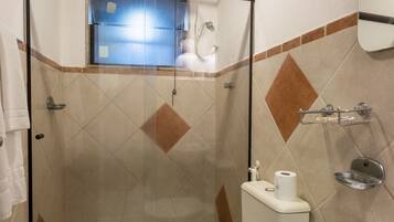 Une salle de bain avec une douche à parois de verre, des toilettes et un lavabo.