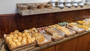 Een buffet met diverse broden en gebak.