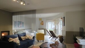 Un salon moderne avec un canapé, des fauteuils, une table basse et une cheminée.