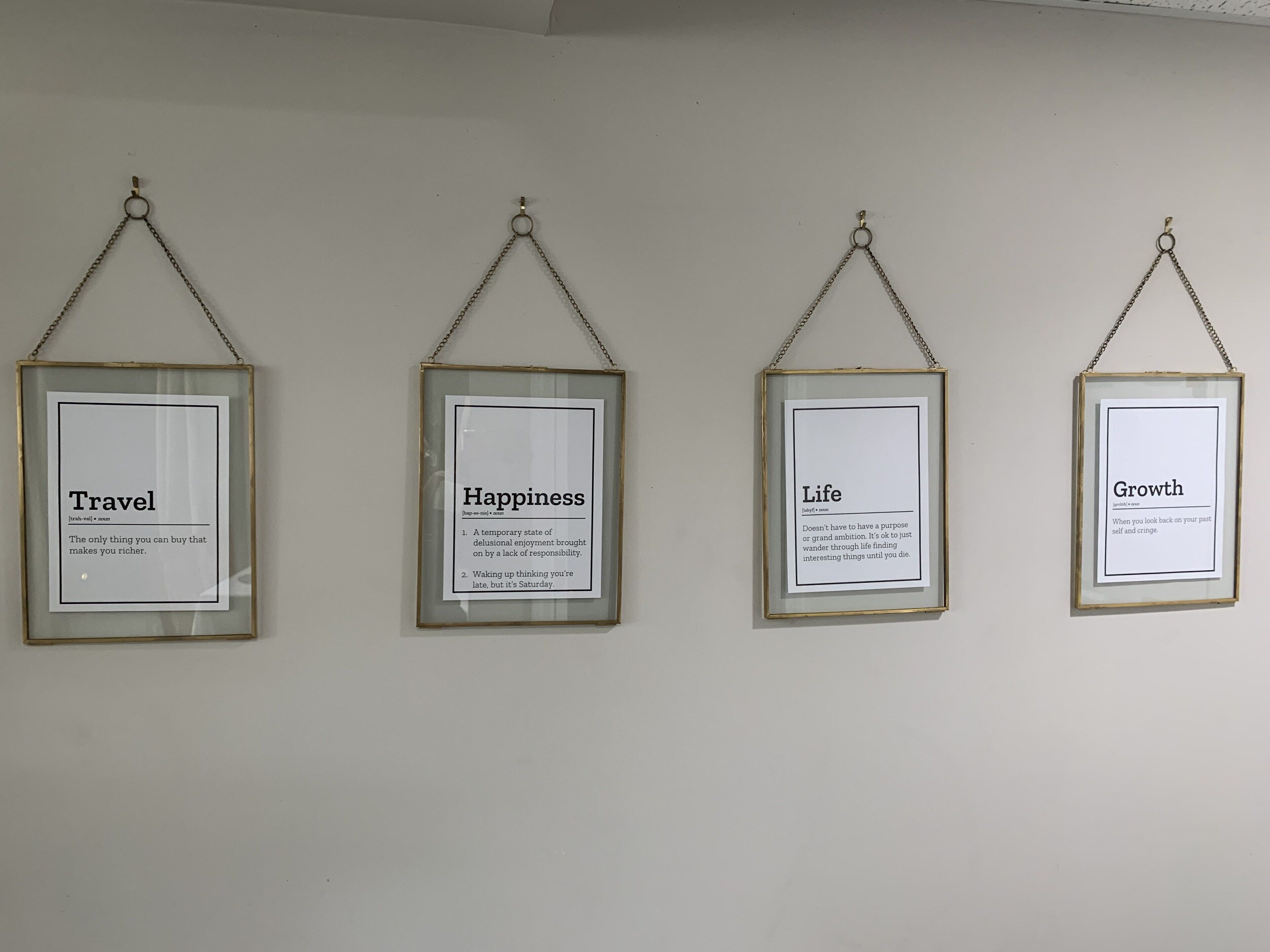 Four framed quotes on a wall.
