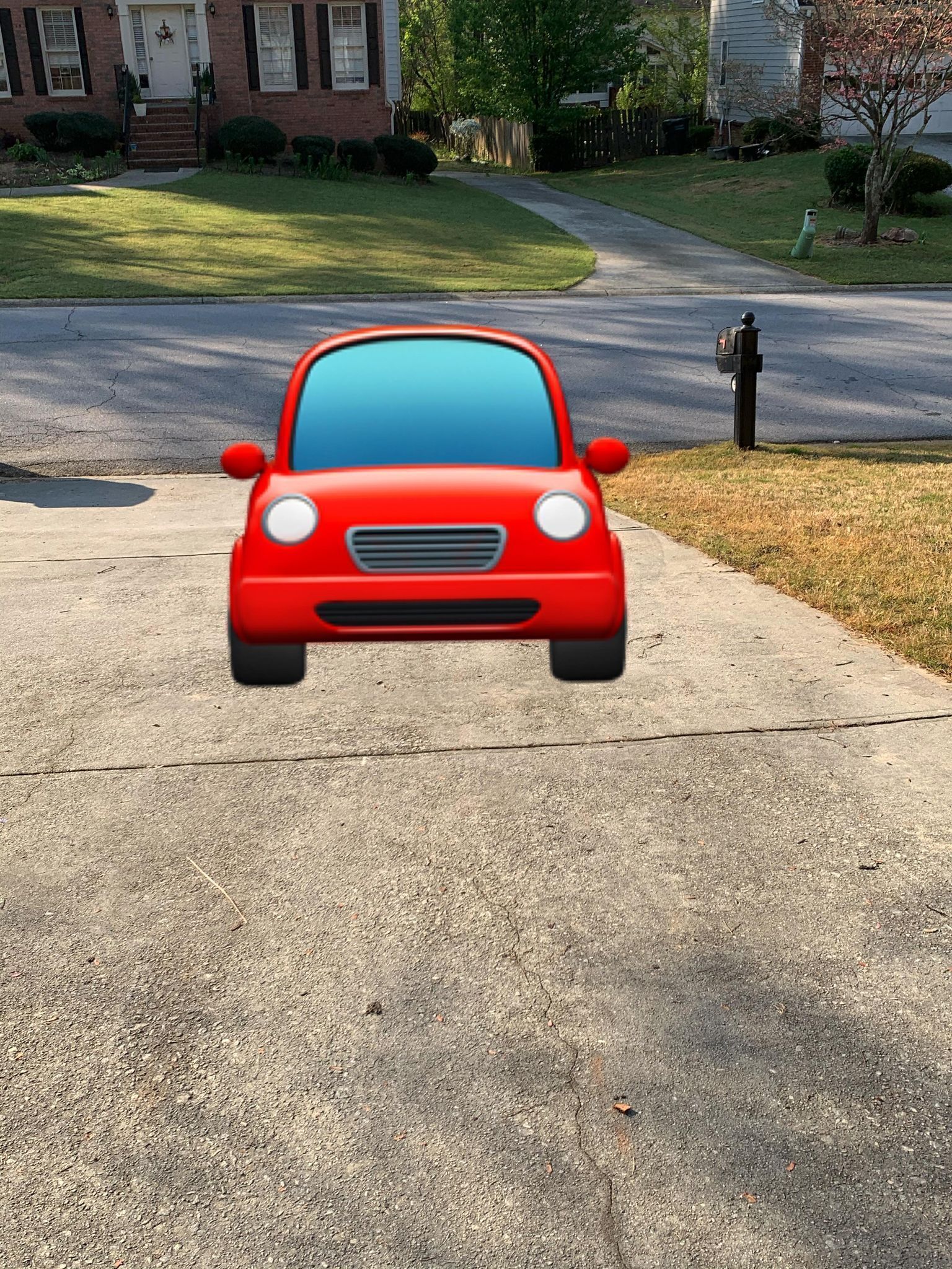 Ein rotes Auto auf einer Einfahrt in einer Wohngegend.