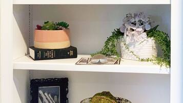 A shelf with decorative items including a wooden sign, a miniature Eiffel Tower, a crystal bowl, and a small figurine.
