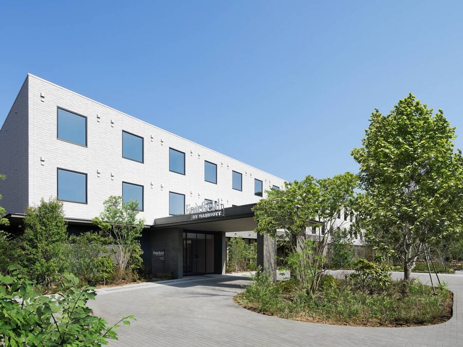 A modern building with a flat roof, large windows, and a sign that reads "Fairfield by Marriott."