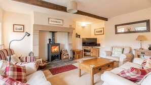 Una sala de estar acogedora con chimenea, televisor y asientos cómodos.