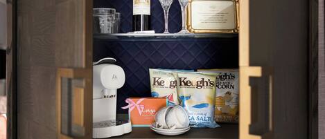 A kitchen with a wine bottle, glasses, and packaged food items.