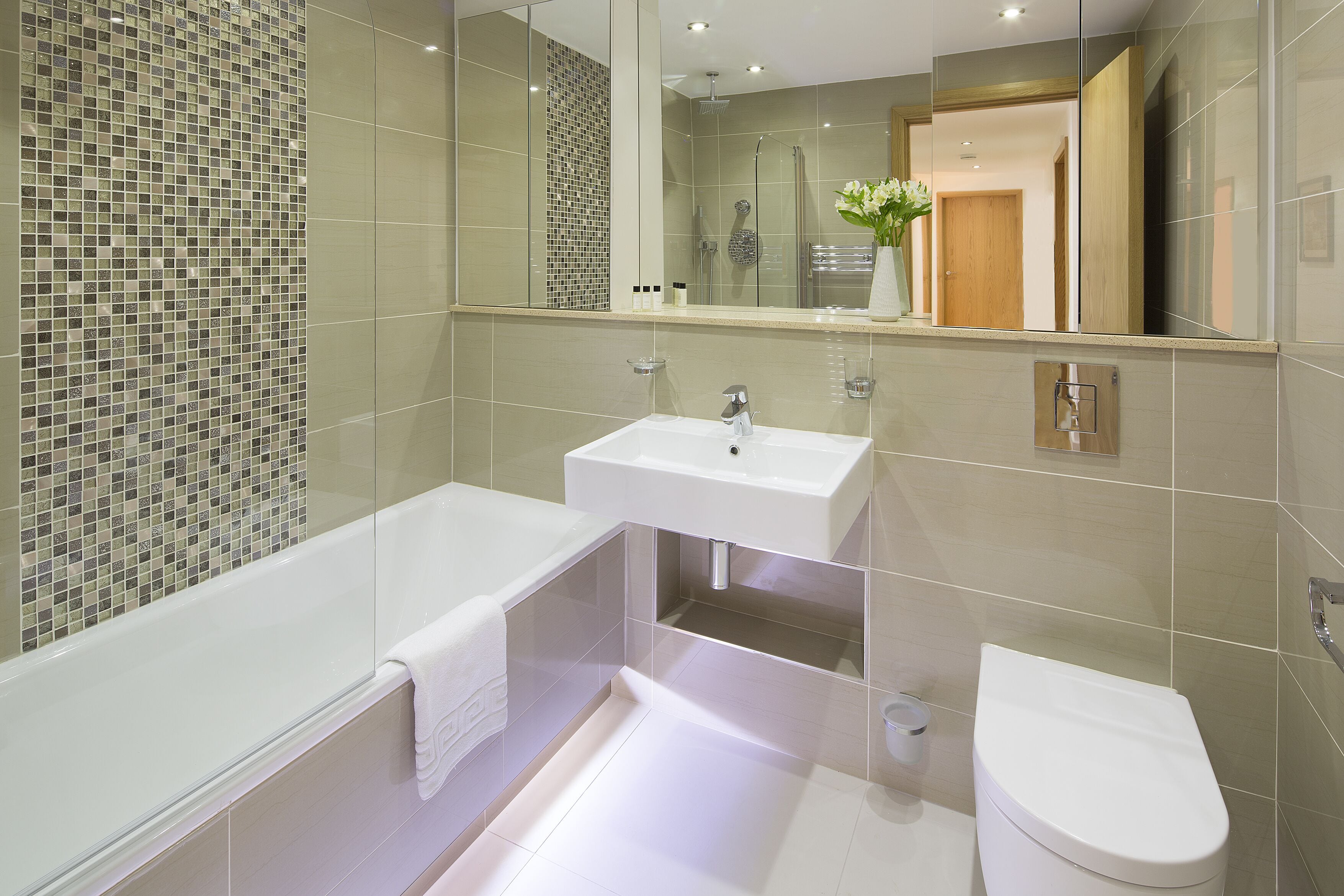 Une salle de bain moderne avec une douche à parois de verre, un lavabo blanc et des toilettes.