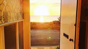 A doorway leading to a street with a sunset view.