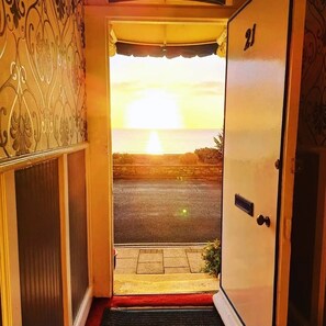 Una puerta que da a una calle con vista al atardecer.