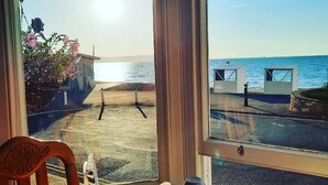 A table with a view of the beach and ocean through large windows. - Penn House Hotel (Weymouth)