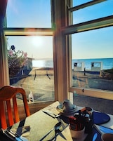 Una mesa con vistas a la playa y al océano a través de amplios ventanales.