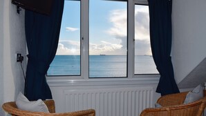 A room with a view of the sea, featuring two wicker chairs and a white radiator. - Penn House Hotel (Weymouth)