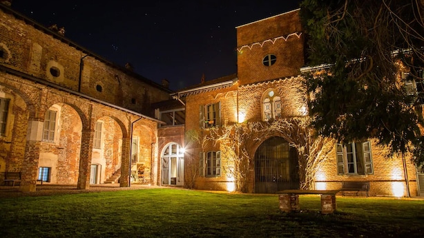 A historic building with arched windows and a courtyard at night.