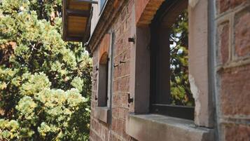 Ein Backsteinhaus mit einem Fenster und einem Holzbalken darüber.
