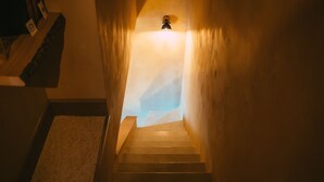 Un escalier surmonté d’un luminaire, menant à un palier.