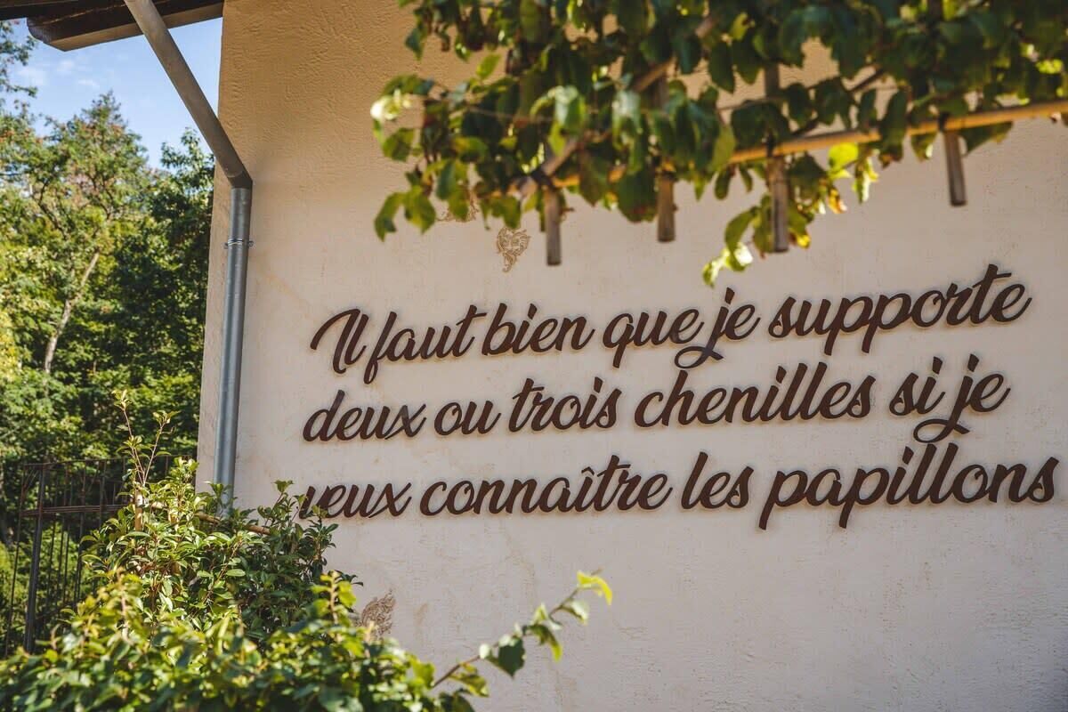Paredes com uma frase em francês numa fonte decorativa.