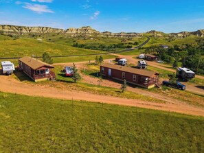 Una proprietà rurale con una grande casa, diversi camper e una strada sterrata.