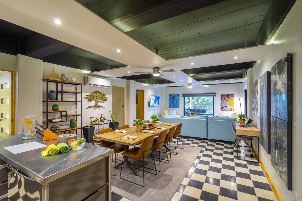 Une cuisine moderne avec un carrelage à motifs géométriques, un coin repas avec des chaises et un bar avec un comptoir.