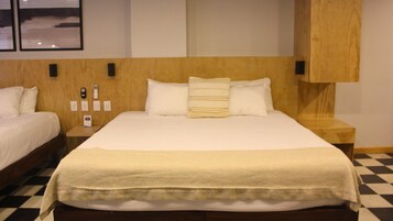Ein Hotelzimmer mit einem großen Bett, zwei Nachttischen, einem Holzkopfstück und einem Schachbrettboden.