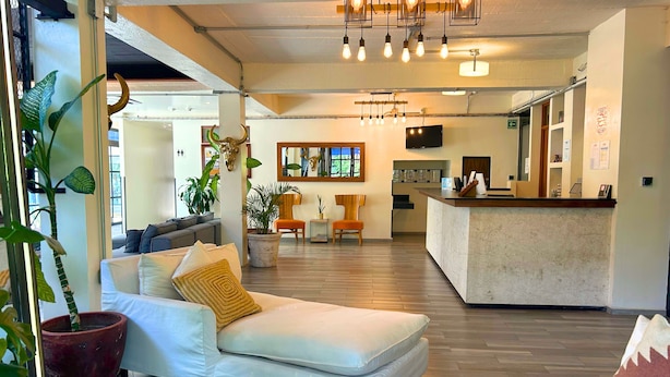 Een moderne woonkamer met een witte bank, een salontafel en een eetgedeelte met een bar.