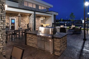 An outdoor patio with a built-in grill, seating area, and stone walls. - Residence Inn by Marriott St. Louis Chesterfield (Chesterfield)