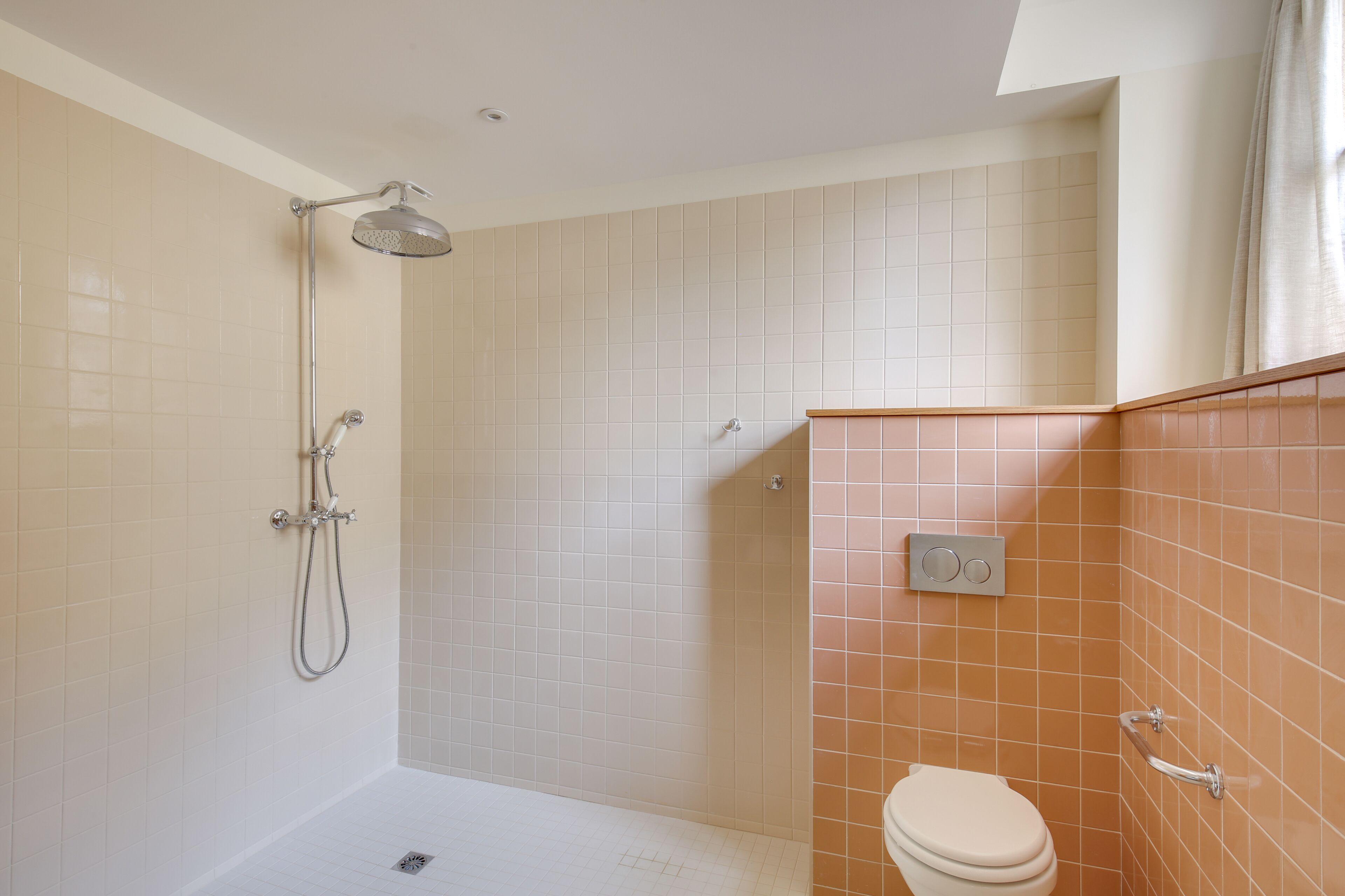 A bathroom with a shower, toilet, and a hand dryer.