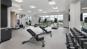 A gym with weight benches, dumbbells, and exercise machines.