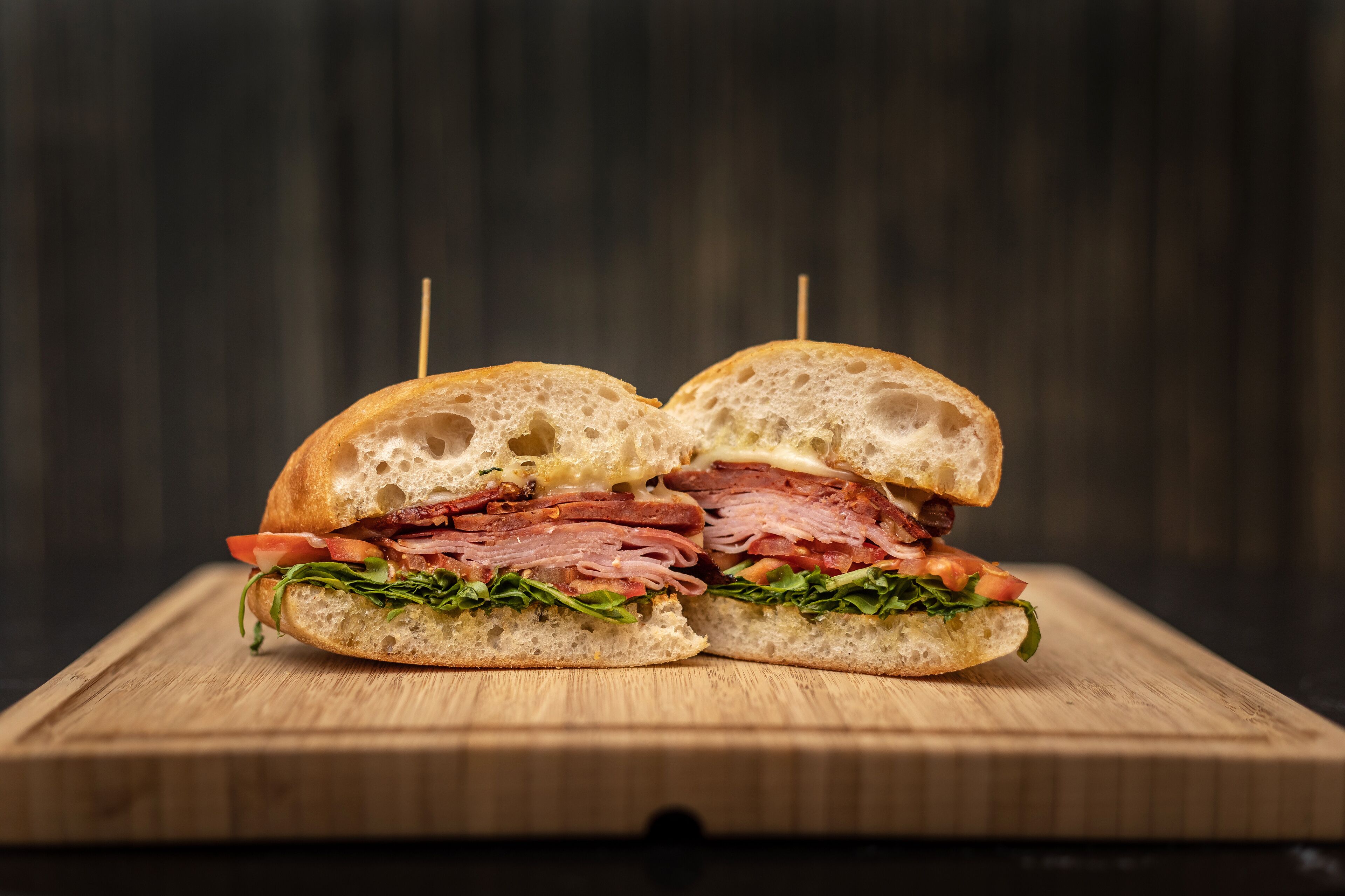A sandwich on a wooden cutting board.