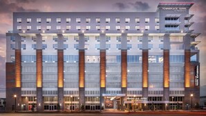 A modern hotel with a prominent entrance, large windows, and a sign indicating it is a TownePlace Suites by Marriott.