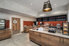 Una cocina moderna con armarios de madera, una isla central y un espacio para café.