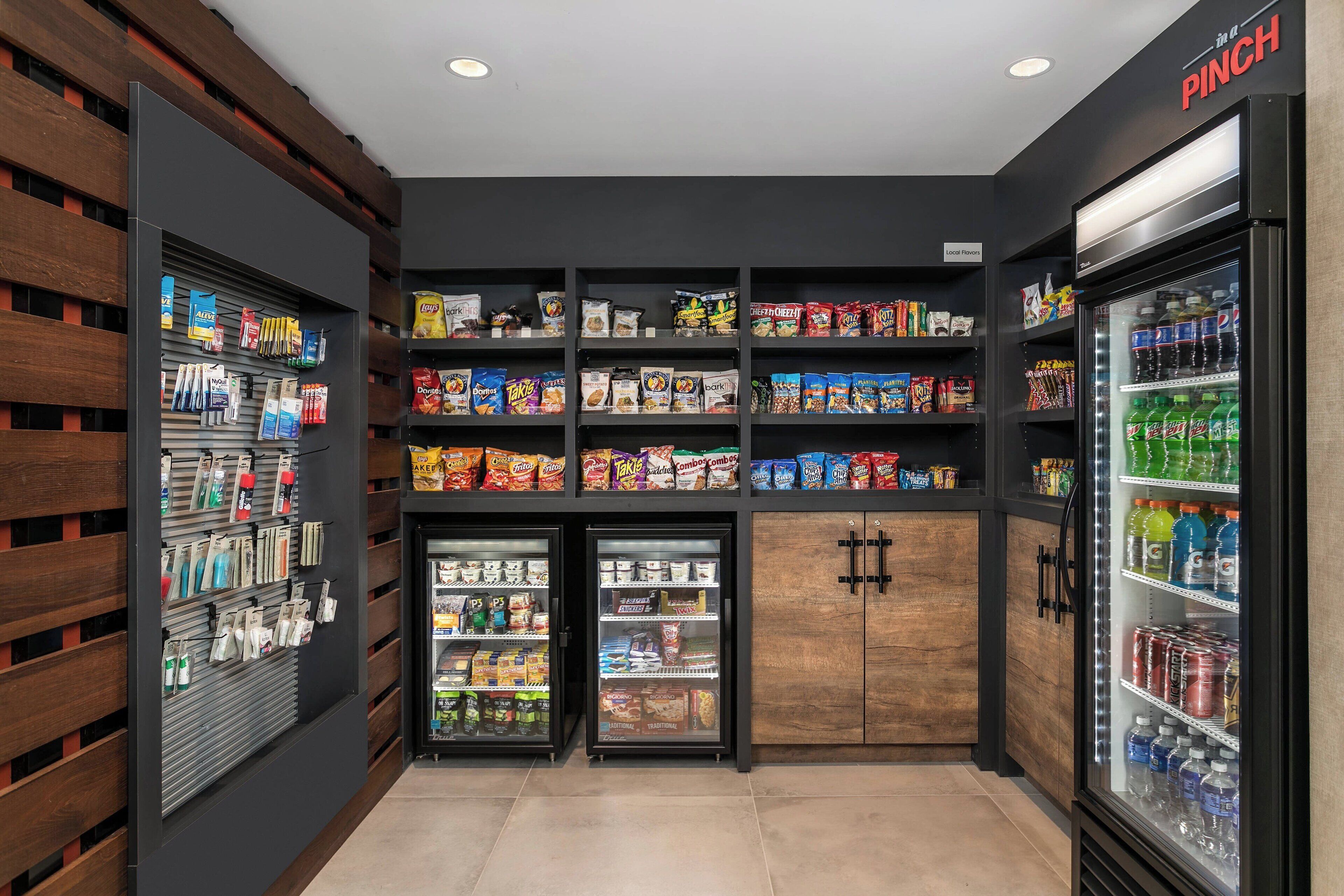 A snack and beverage vending area with multiple shelves stocked with various snacks and drinks.