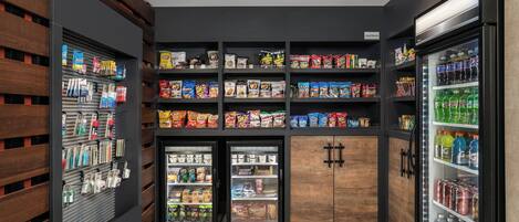 A snack and beverage vending area with multiple shelves stocked with various snacks and drinks.