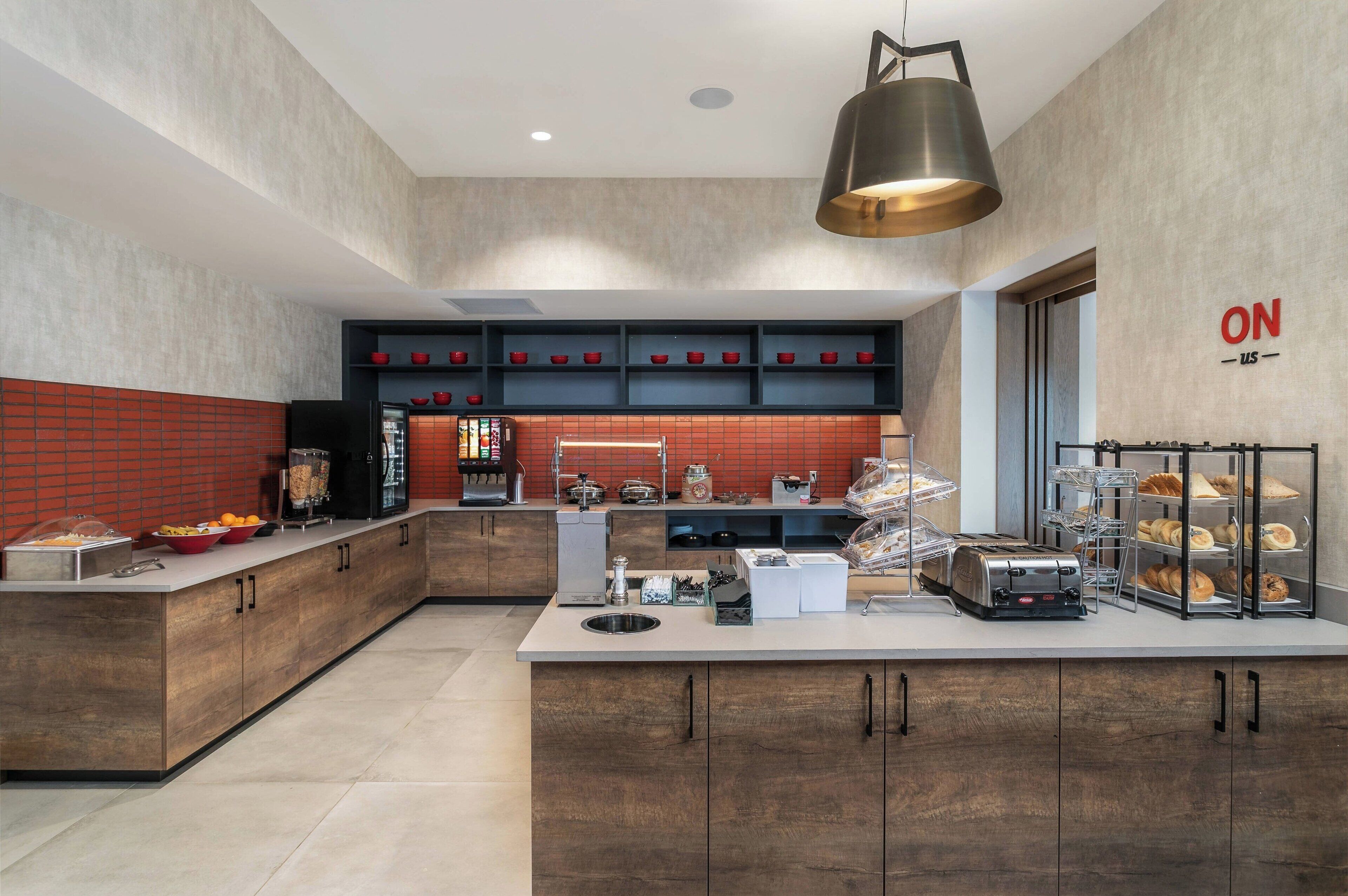 A modern kitchen with a central island, built-in shelves, and a variety of appliances and food items.