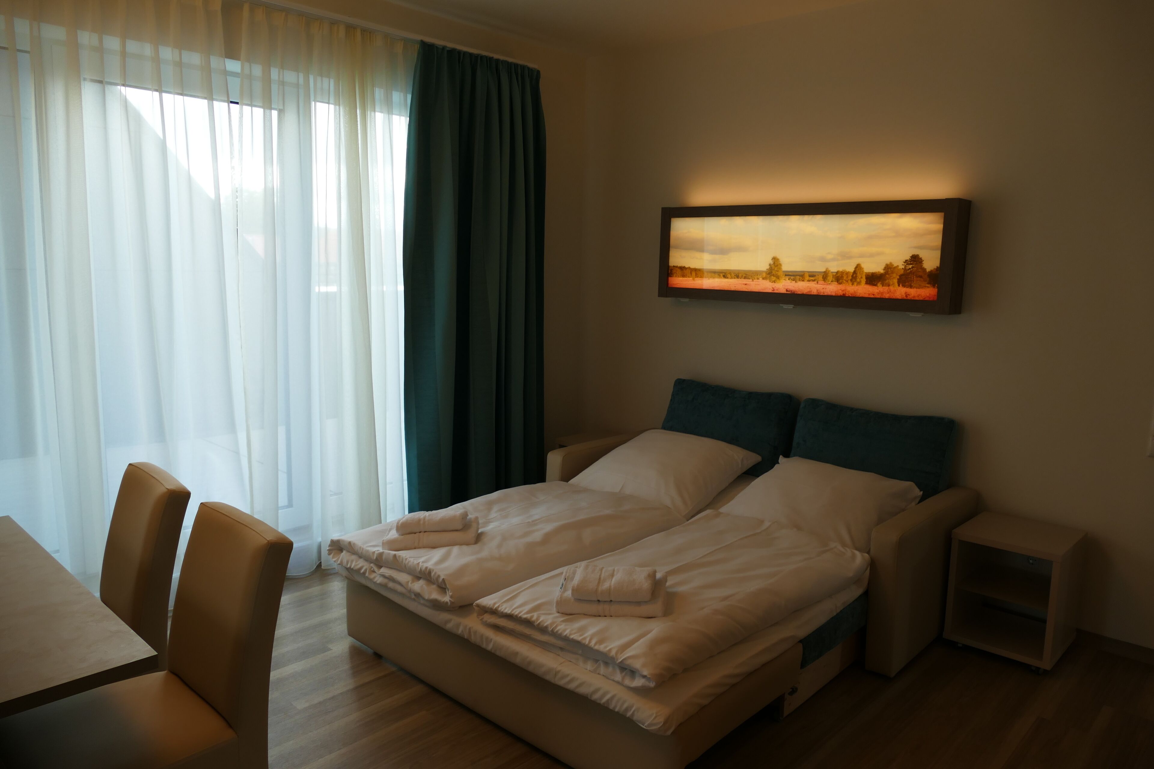 Una habitación de hotel con una cama, un escritorio y una silla.